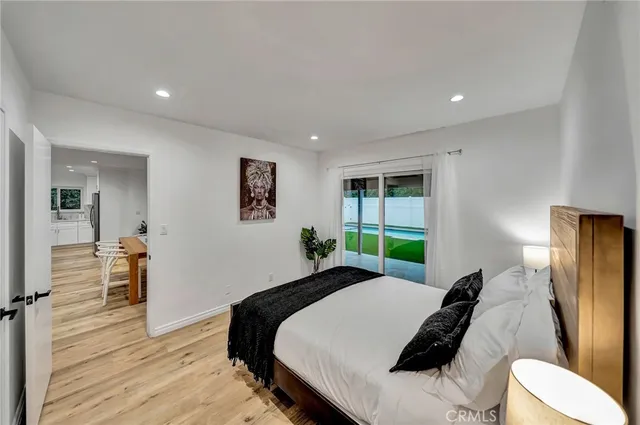 a bedroom with a bed and wooden floor