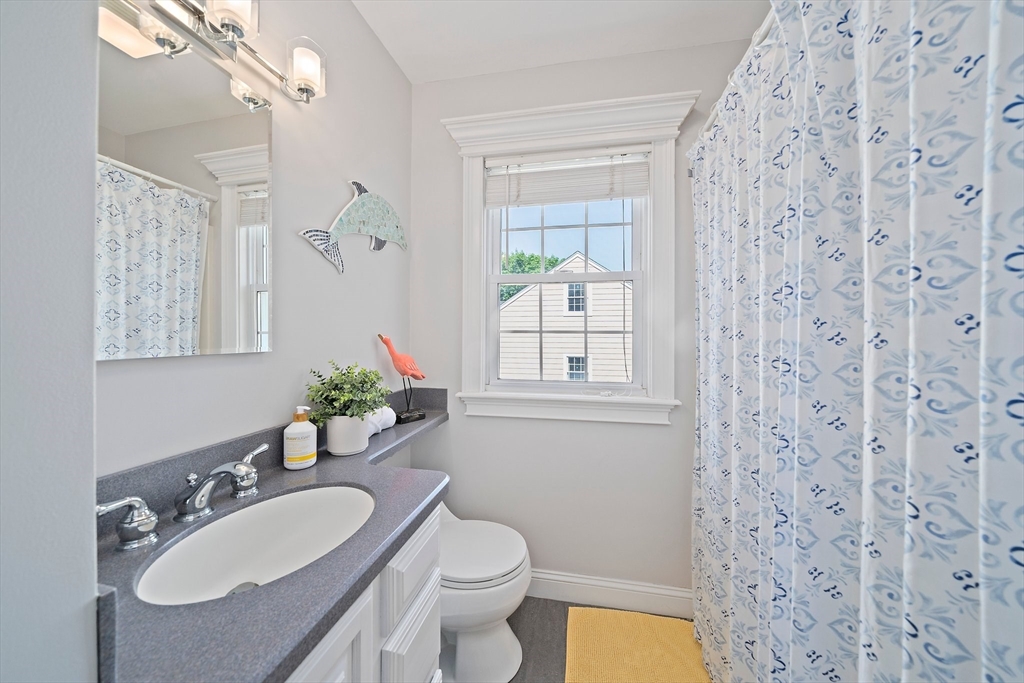 77 Jefferson Shores Road Wareham, MA 02532 - Photo 15 of 34 a bathroom with a granite countertop sink a toilet a mirror a vanity and shower