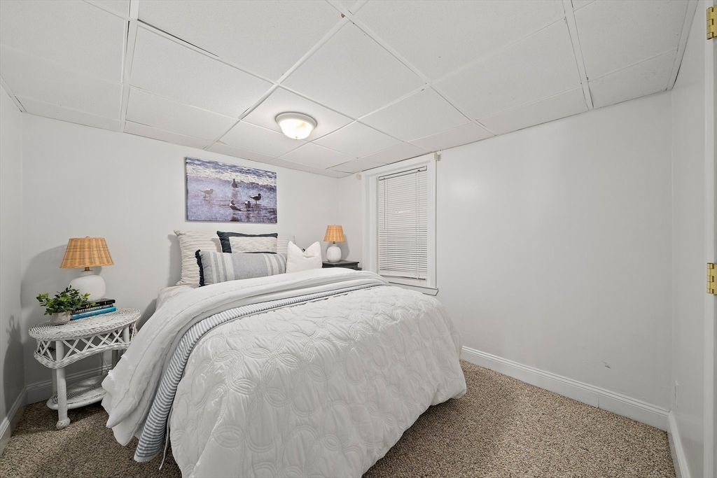 77 Jefferson Shores Road Wareham, MA 02532 - Photo 27 of 34 a bedroom with a bed and a painting on the wall