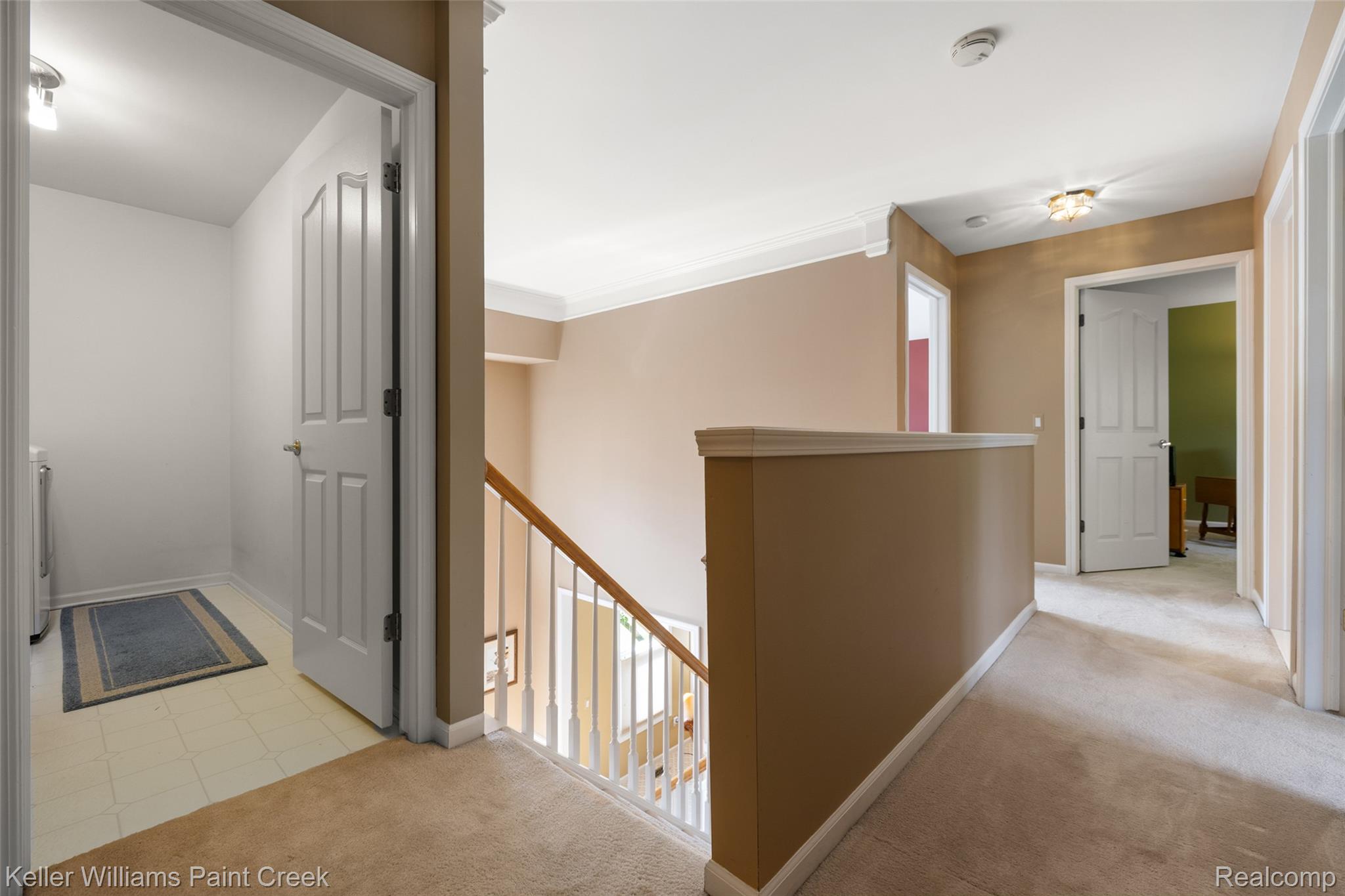 1933 Catlin Drive Rochester, MI 48306 - Photo 25 of 54 Hallway with an upstairs landing, light colored carpet, and crown molding