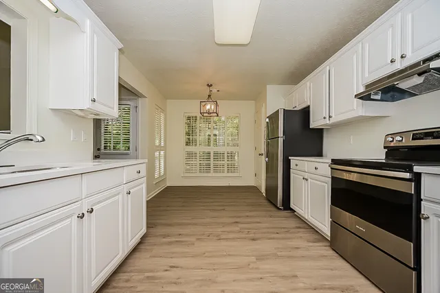a kitchen with granite countertop a refrigerator stove and sink