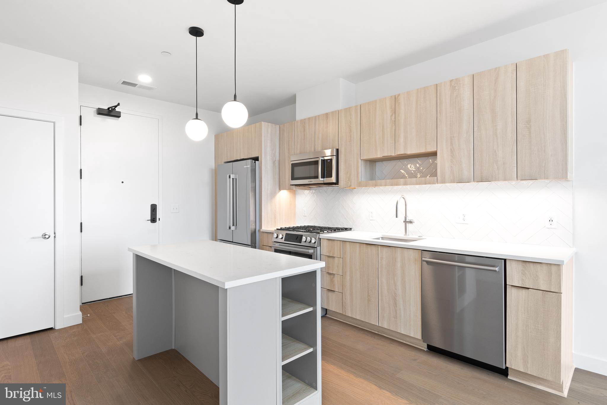 7175 12th Street Northwest, Unit 610 Washington, DC 20012 - Photo 12 of 35 a kitchen with kitchen island a sink stainless steel appliances and cabinets