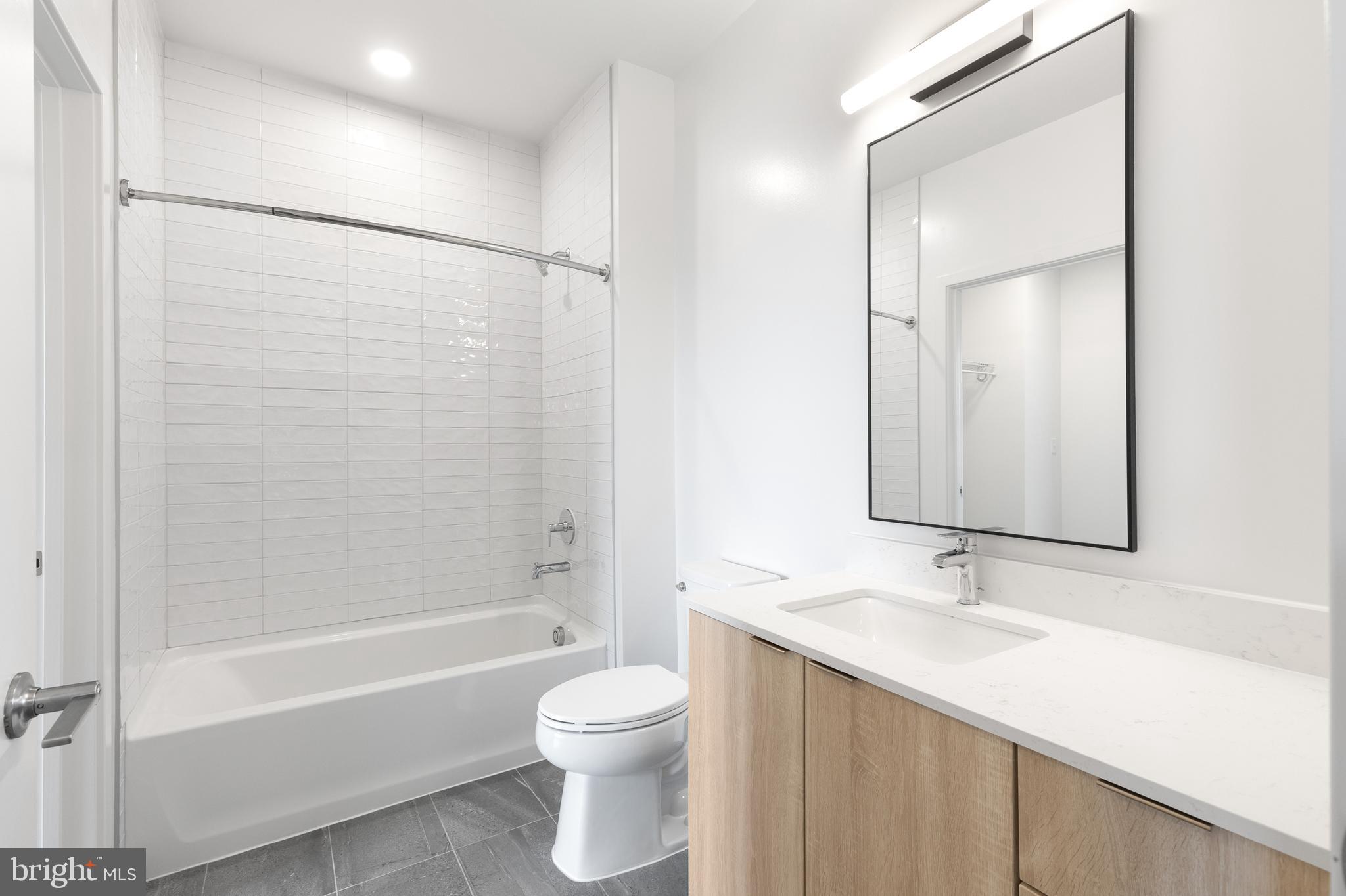 7175 12th Street Northwest, Unit 610 Washington, DC 20012 - Photo 9 of 35 a bathroom with a bathtub shower sink vanity and toilet