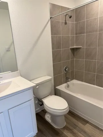 a white toilet and tub sitting next to a bathroom sink