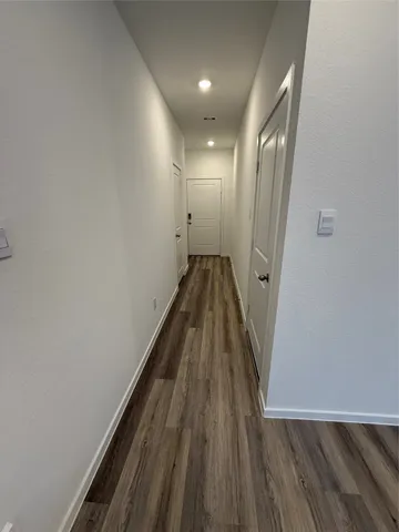 a view of a hallway with wooden floor