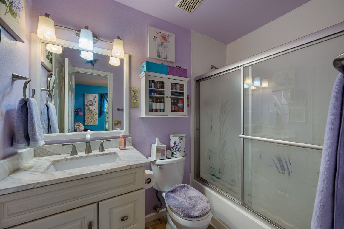6095 Negley, Unit A Kyle, TX 78640 - Photo 18 of 40 a bathroom with a granite countertop sink toilet a mirror and shower