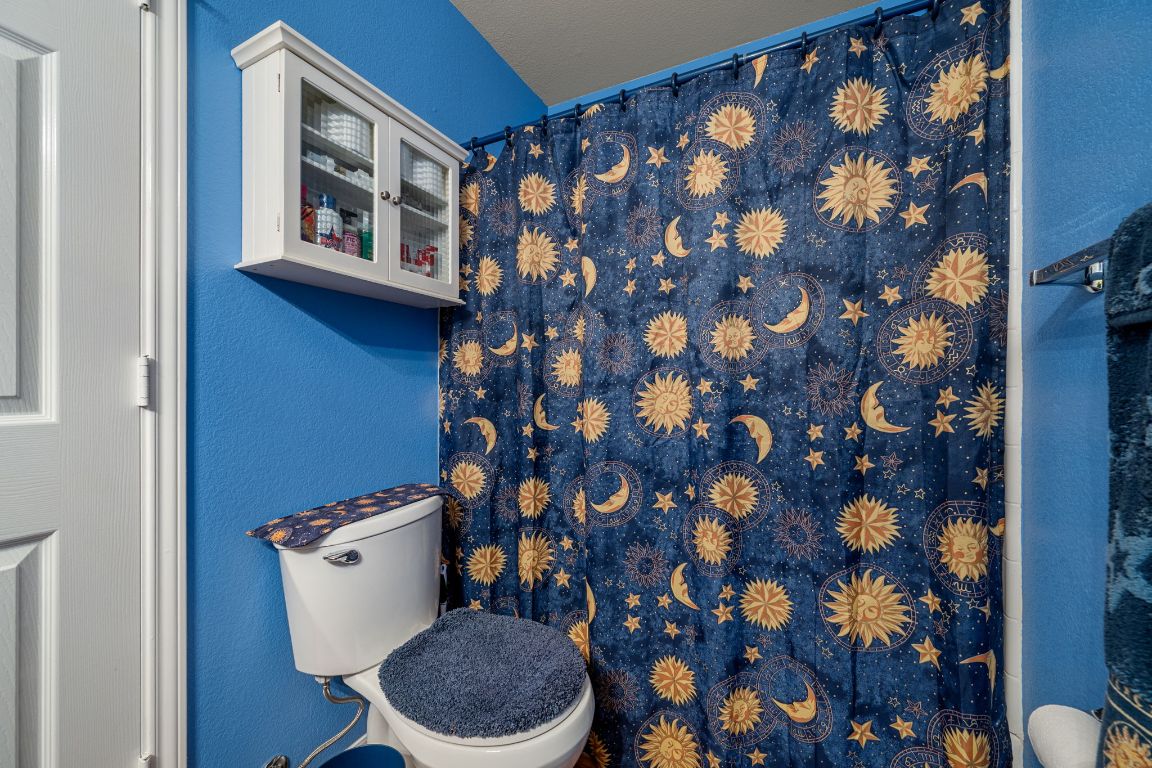 6095 Negley, Unit A Kyle, TX 78640 - Photo 25 of 40 a bathroom with a toilet and a shower curtain