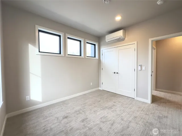 an empty room with windows and closet