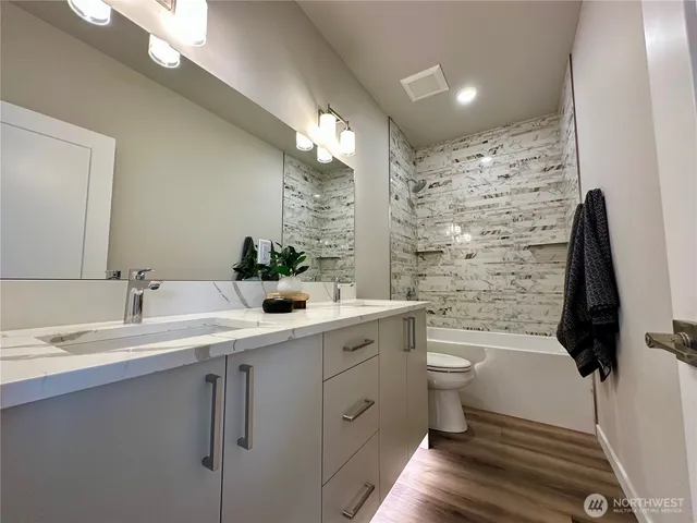 a bathroom with a double vanity sink toilet and shower