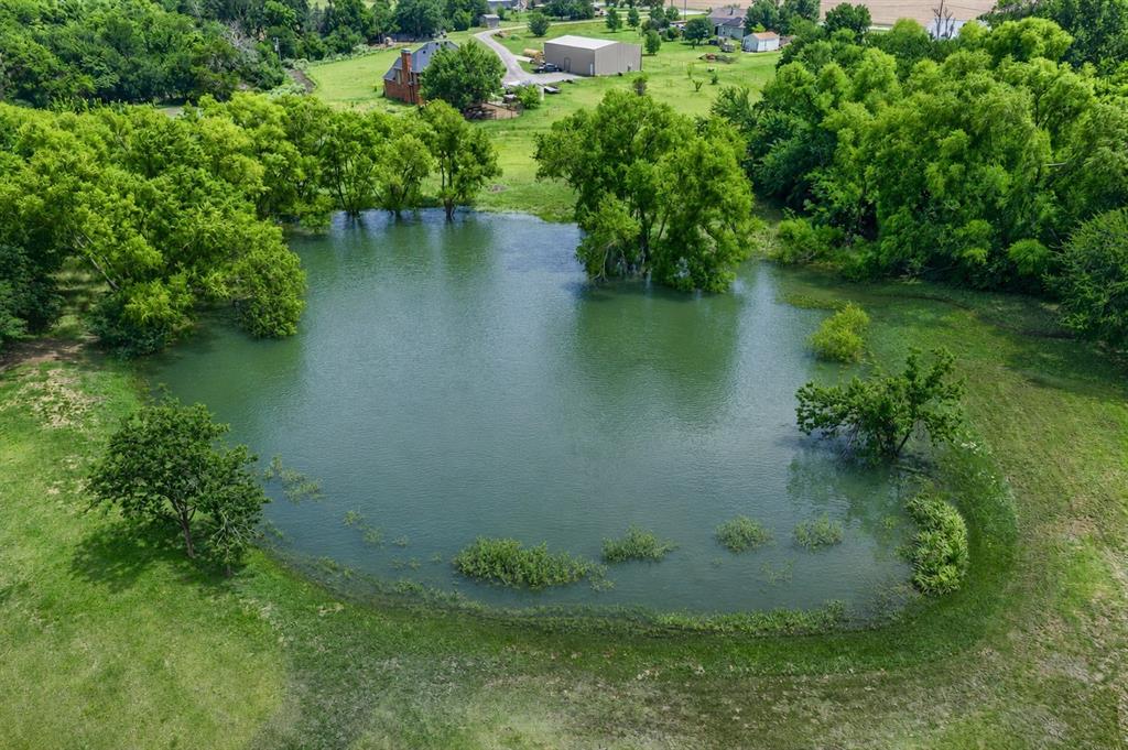 900 Hodgins Road Van Alstyne, TX 75495 - Photo 3 of 10 Expansive pond with lush green surroundings