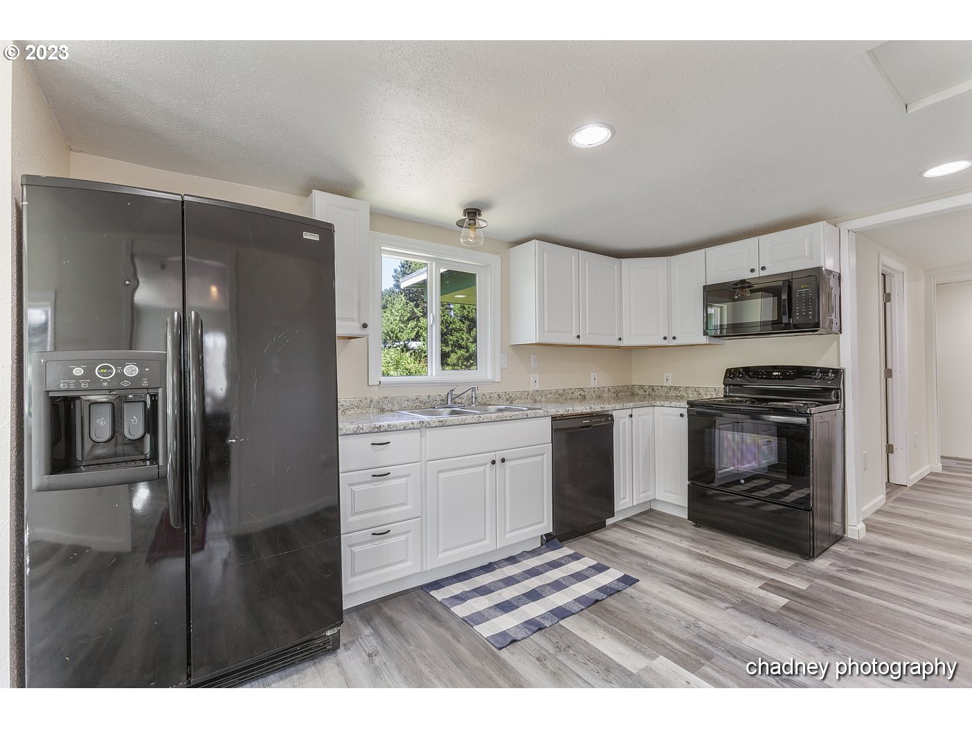5707 Northwest Rhododendron Street Newport, OR 97365 - Photo 4 of 20 a kitchen with granite countertop a refrigerator stove and sink