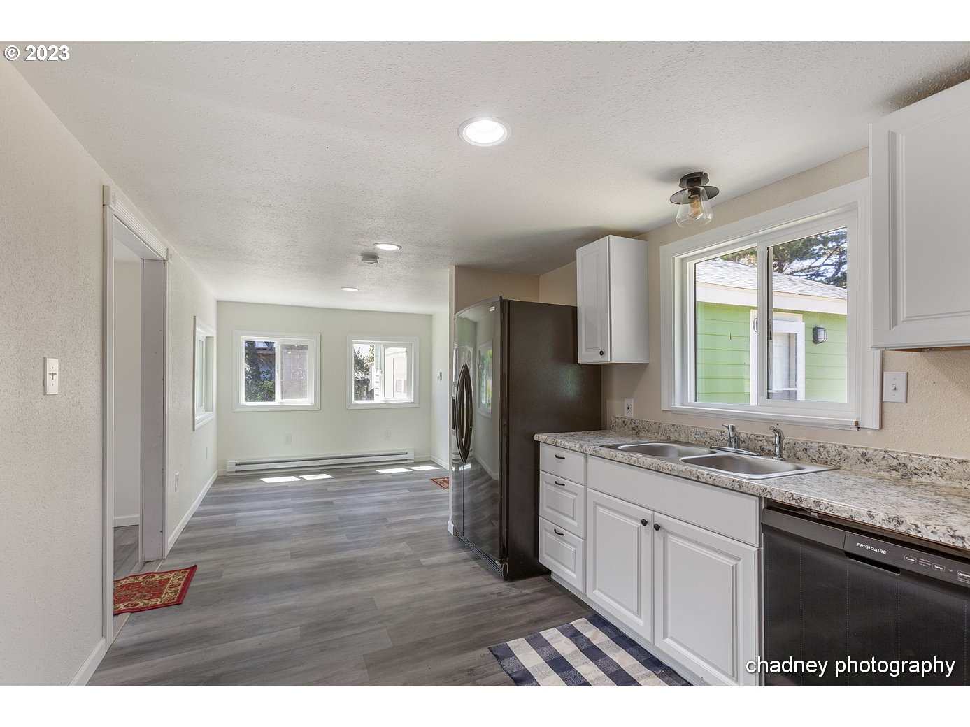 5707 Northwest Rhododendron Street Newport, OR 97365 - Photo 5 of 20 a kitchen with a sink dishwasher a refrigerator and a stove with wooden floor