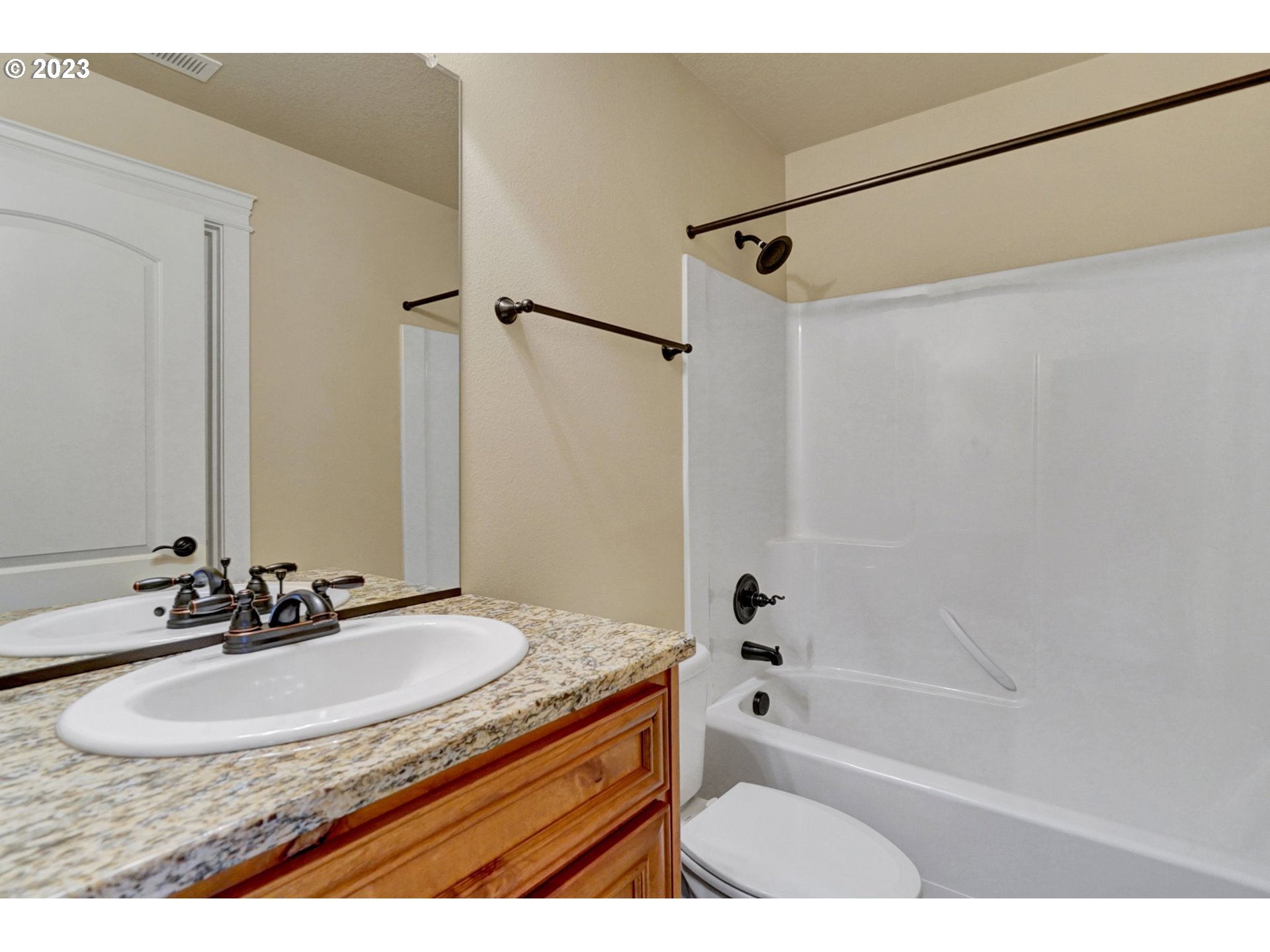 235 North 33rd Court Ridgefield, WA 98642 - Photo 24 of 30 a bathroom with a granite countertop sink a mirror a shower and a bathtub