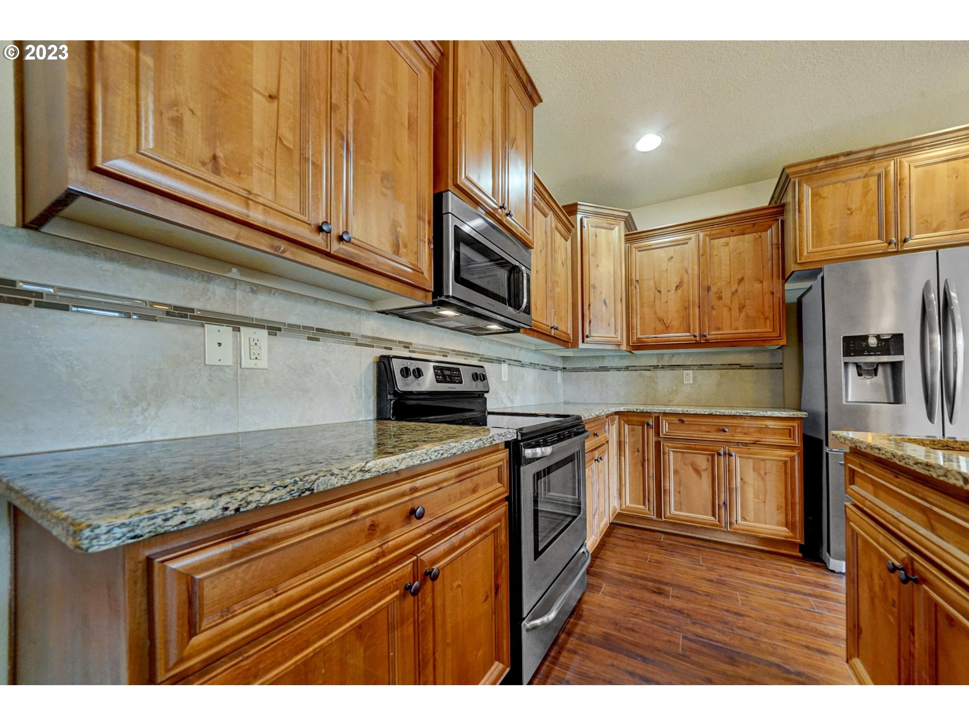 235 North 33rd Court Ridgefield, WA 98642 - Photo 3 of 30 a kitchen with stainless steel appliances granite countertop a sink stove and refrigerator