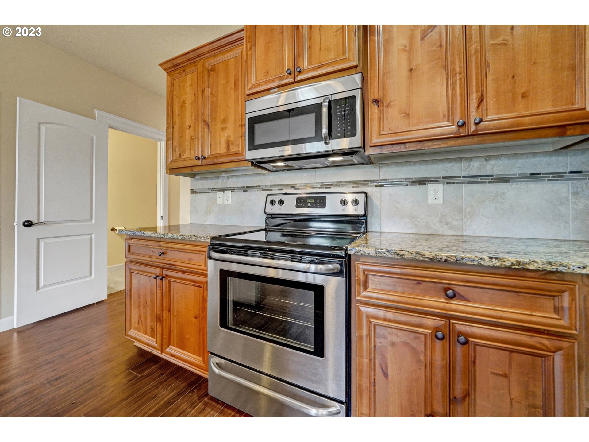 235 North 33rd Court Ridgefield, WA 98642 - Photo 4 of 30 a kitchen with stainless steel appliances granite countertop a stove microwave and cabinets