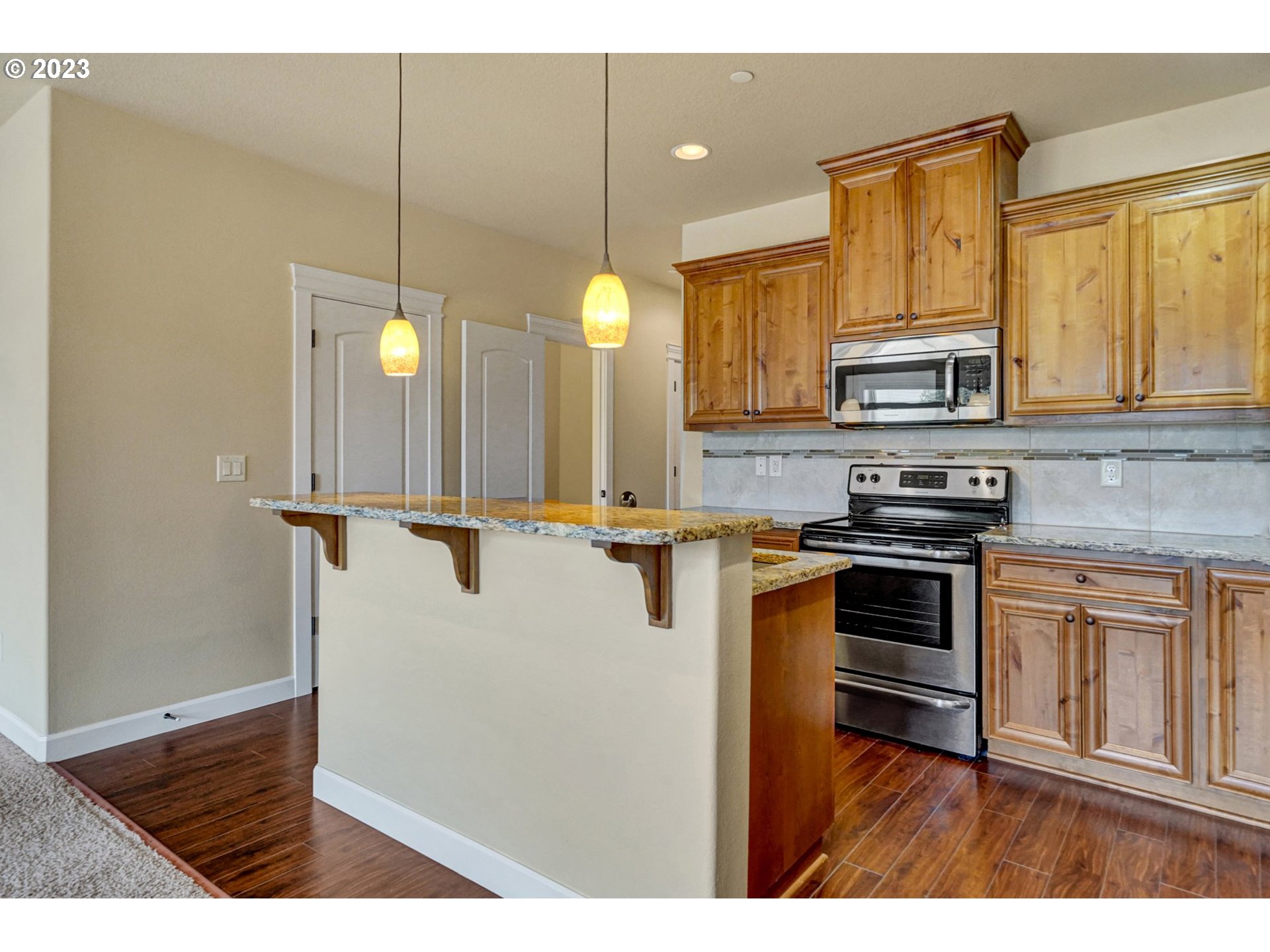 235 North 33rd Court Ridgefield, WA 98642 - Photo 5 of 30 a kitchen with stainless steel appliances a stove sink and cabinets