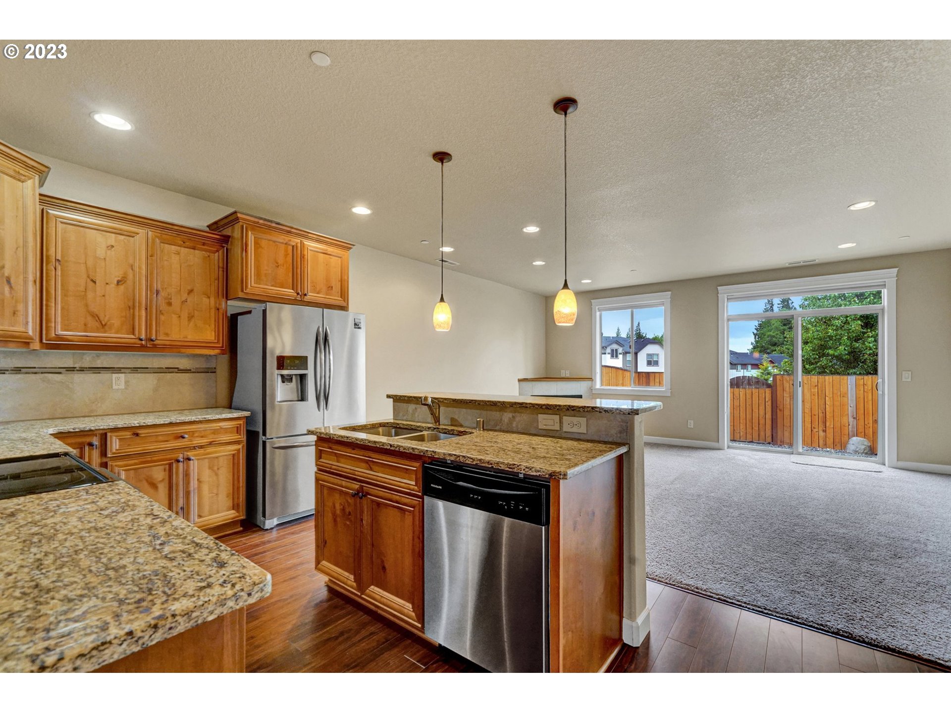 235 North 33rd Court Ridgefield, WA 98642 - Photo 6 of 30 a kitchen with stainless steel appliances granite countertop a sink a stove and a wooden cabinets
