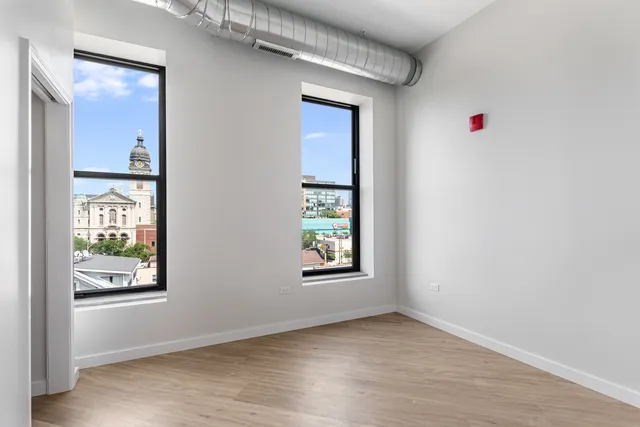 an empty room with windows and closet