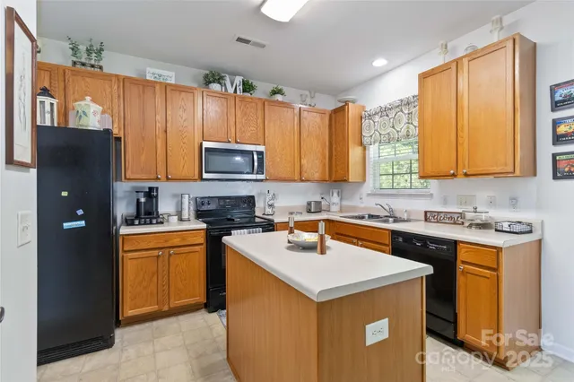 a kitchen with stainless steel appliances granite countertop a stove top oven a sink dishwasher and a refrigerator