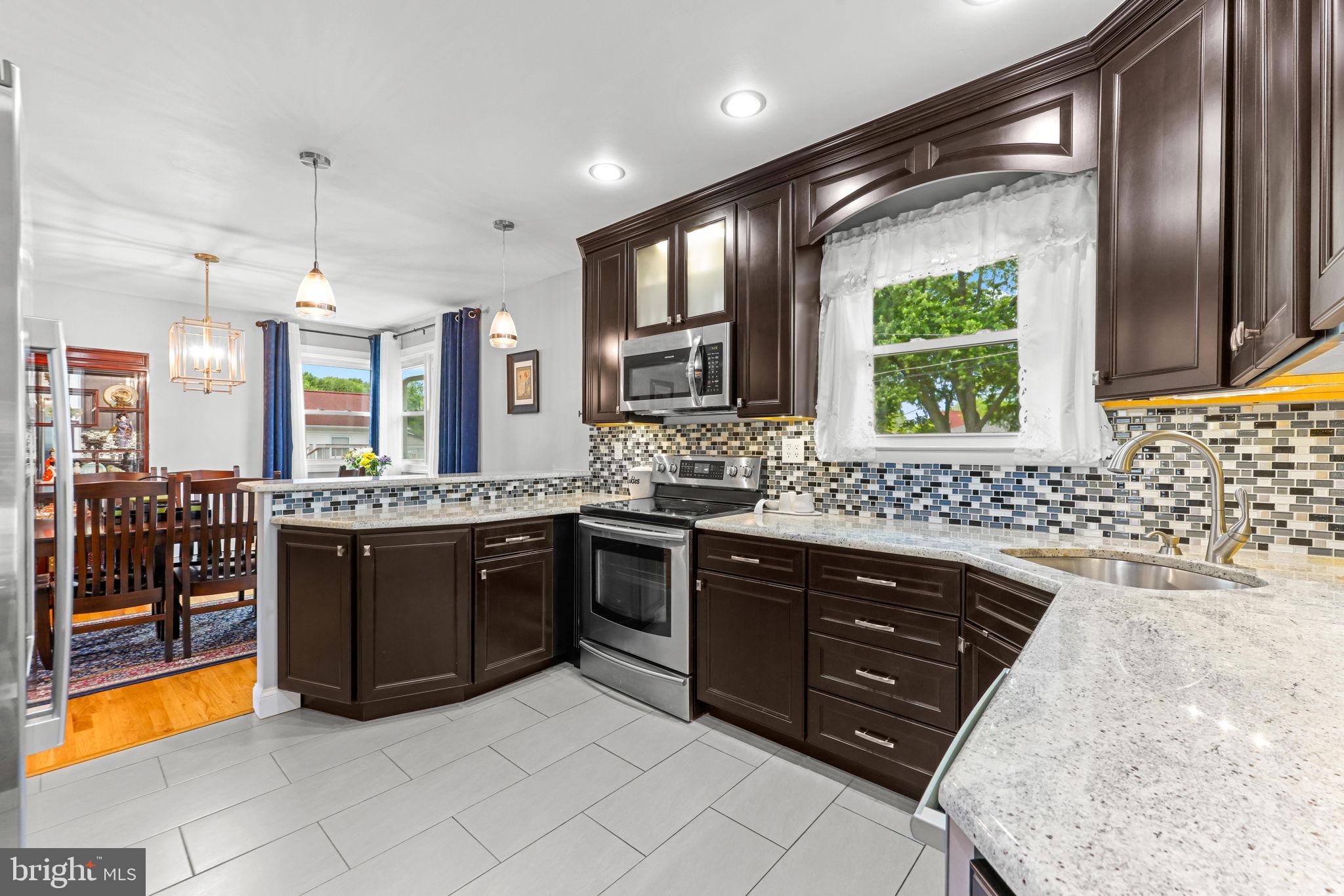 2902 Ritchie Avenue Baltimore, MD 21219 - Photo 12 of 43 a large kitchen with stainless steel appliances granite countertop a sink and a stove