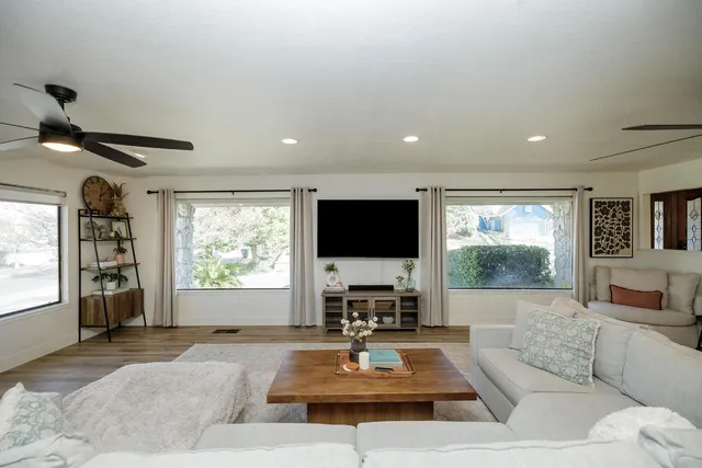 a living room with furniture a window and a flat screen tv