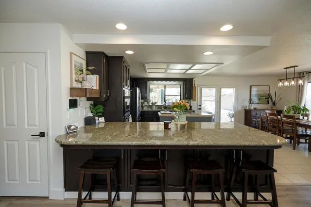 a kitchen with granite countertop a table and chairs in it