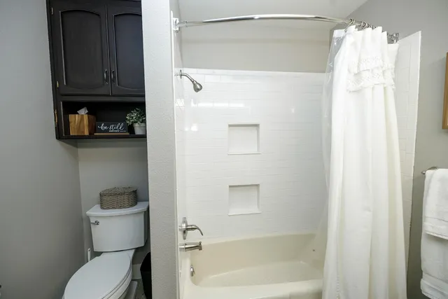 a bathroom with a toilet and a shower