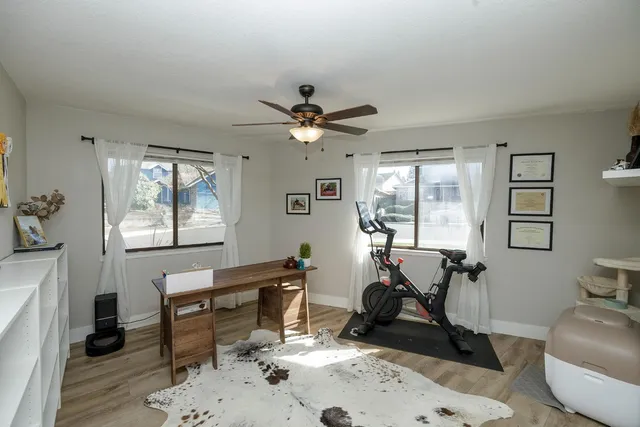 a work room with furniture a rug and a window