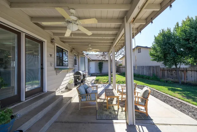 a view of a patio with table and chairs potted plants with wooden floor and fence