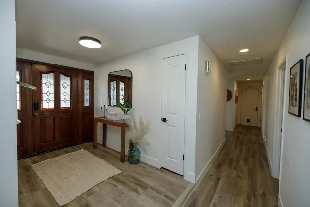 a view of a hallway and a livingroom with wooden floor windows