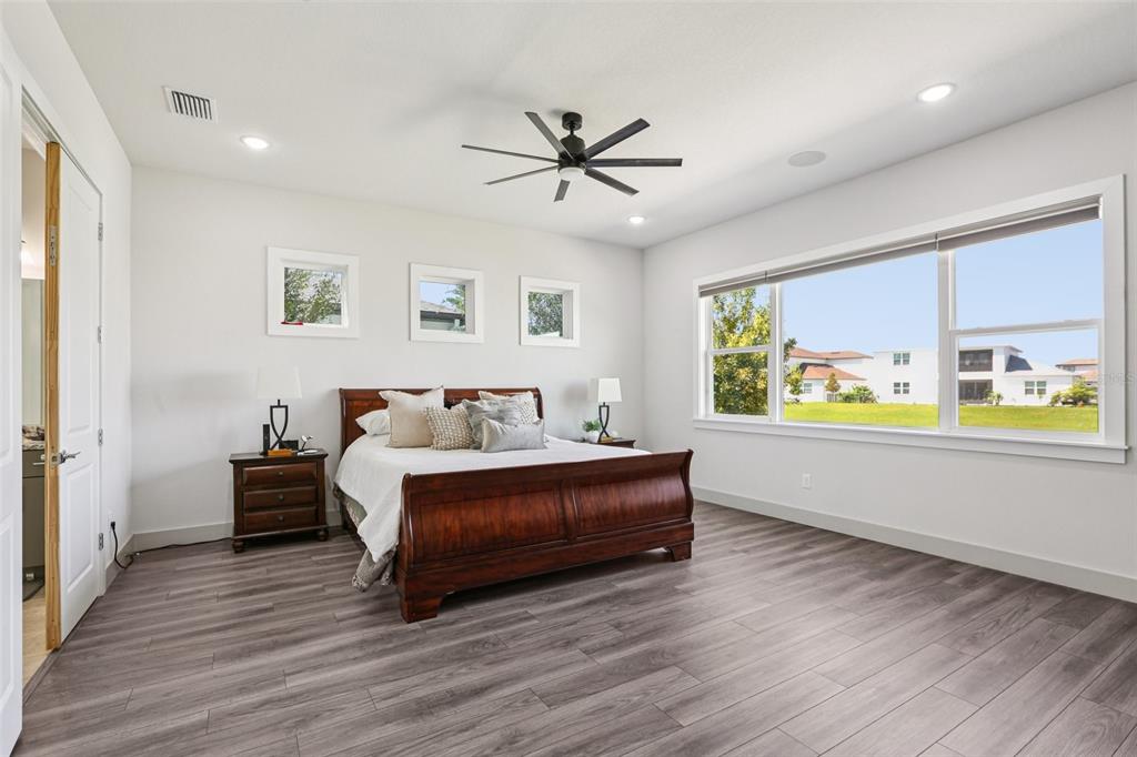 8743 Sanders Tree Loop Wesley Chapel, FL 33545 - Photo 13 of 41 a spacious bedroom with a bed and a large window