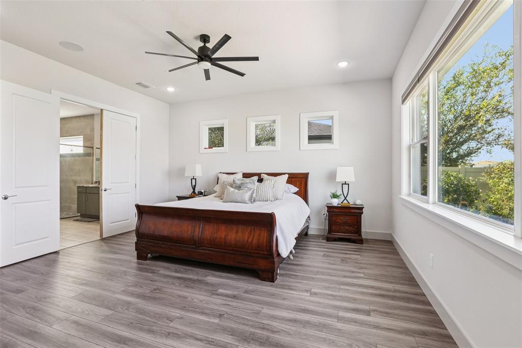 8743 Sanders Tree Loop Wesley Chapel, FL 33545 - Photo 14 of 41 a spacious bedroom with a bed and a large window