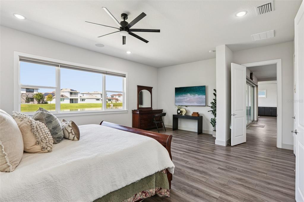 8743 Sanders Tree Loop Wesley Chapel, FL 33545 - Photo 15 of 41 a bedroom with a large bed and a wooden floor