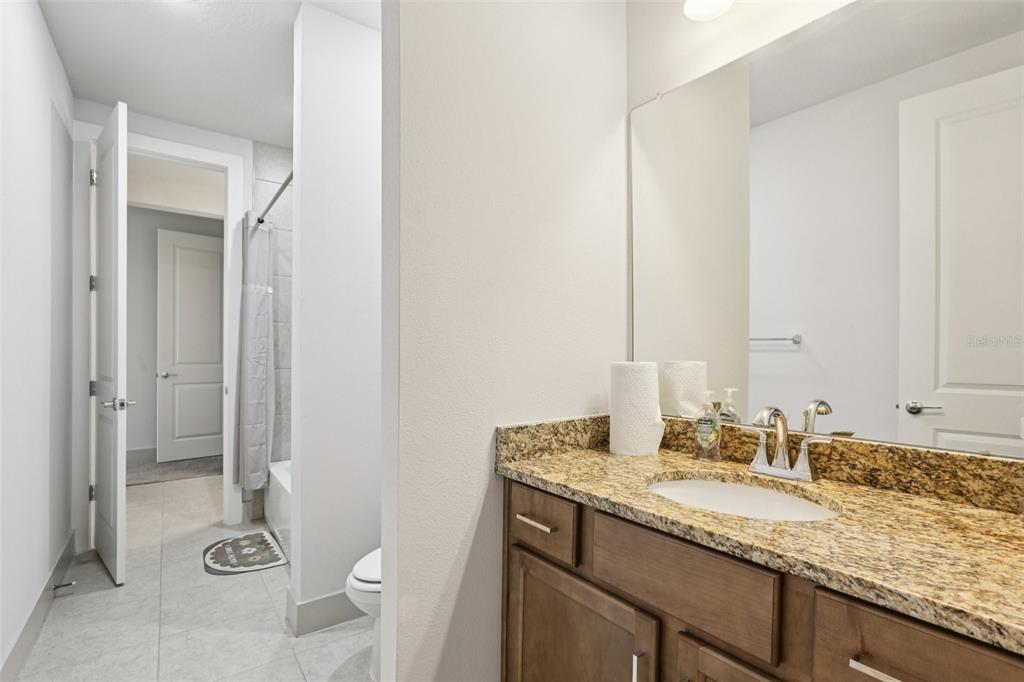 8743 Sanders Tree Loop Wesley Chapel, FL 33545 - Photo 30 of 41 a bathroom with a granite countertop sink and a mirror