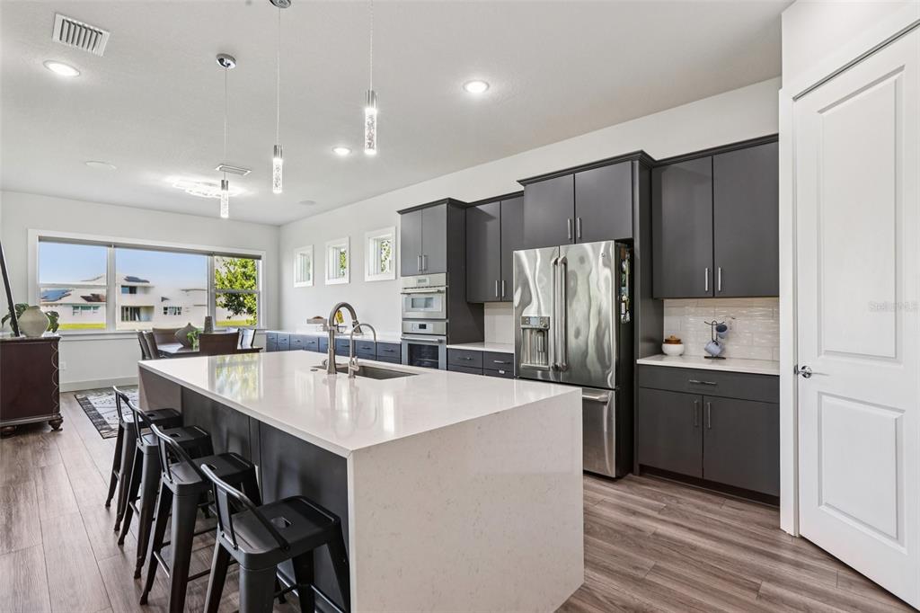 8743 Sanders Tree Loop Wesley Chapel, FL 33545 - Photo 9 of 41 a kitchen with kitchen island a refrigerator stove and sink