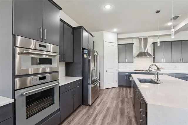 a kitchen with stainless steel appliances a stove sink and refrigerator