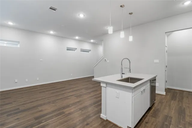a kitchen with a sink and wooden floor