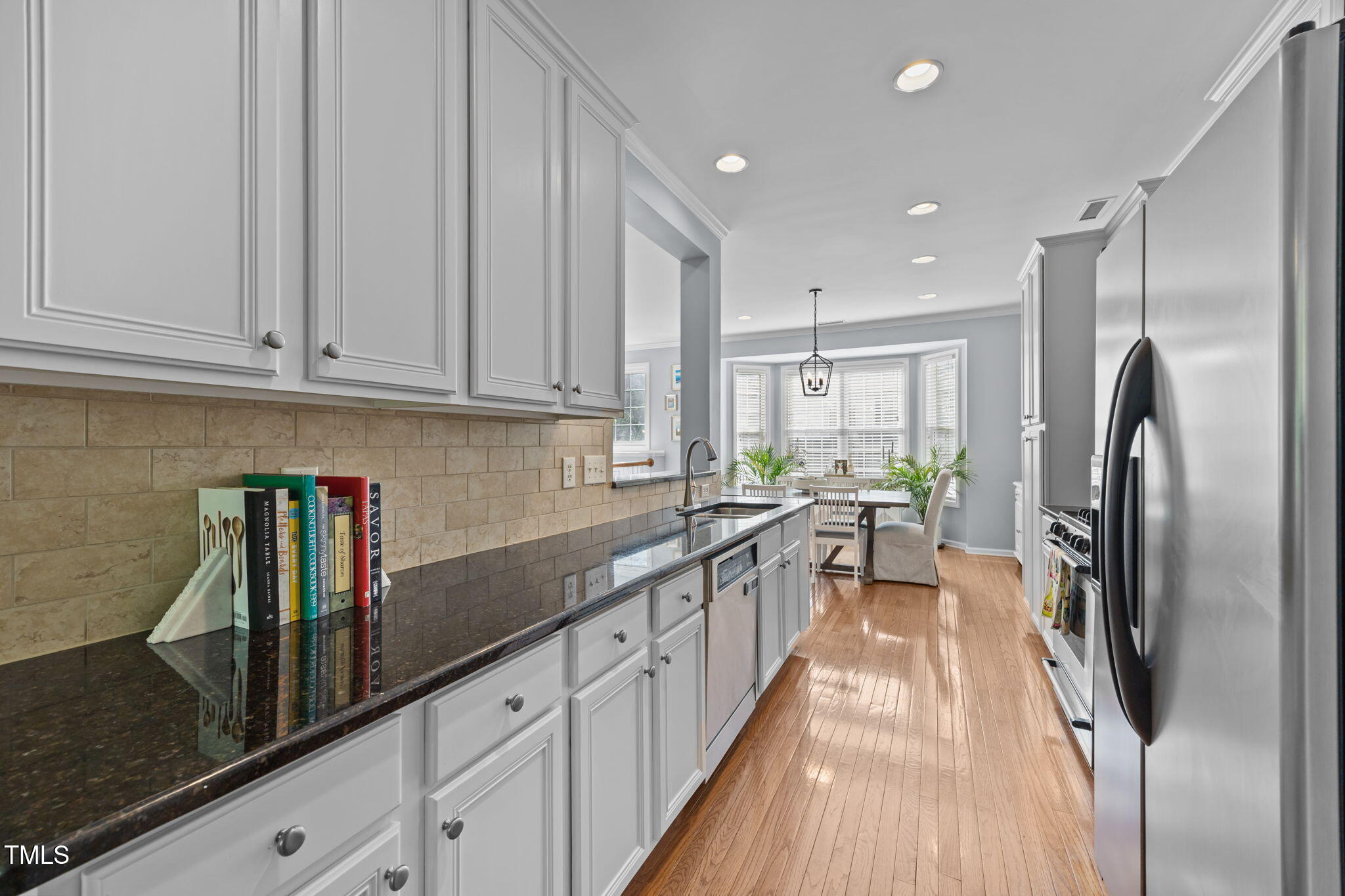 6825 Middleboro Drive Raleigh, NC 27612 - Photo 13 of 38 a kitchen with stainless steel appliances granite countertop a refrigerator a sink dishwasher a stove and white countertops with wooden floor