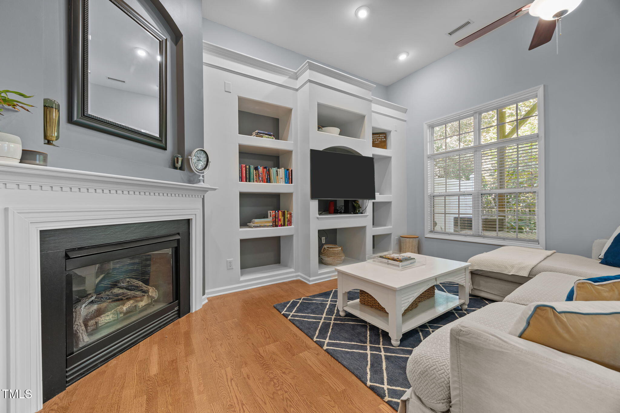 6825 Middleboro Drive Raleigh, NC 27612 - Photo 32 of 38 a living room with furniture a flat screen tv and a fireplace