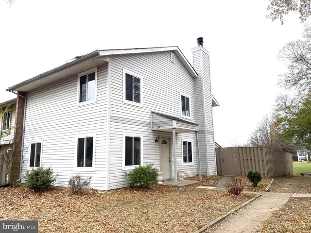 a view of a white house with a small yard and plants