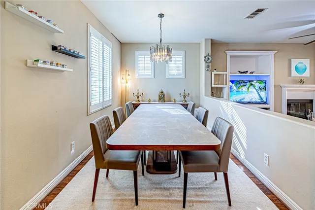 a view of a dining room with furniture a chandelier and wooden floor