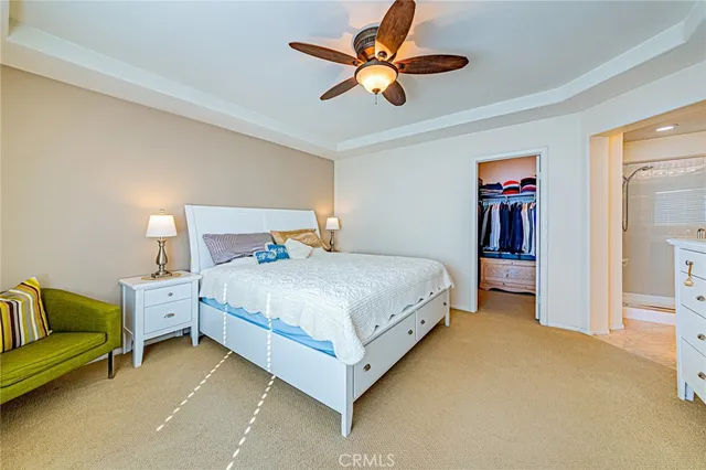 a bedroom with a bed couch and ceiling fan