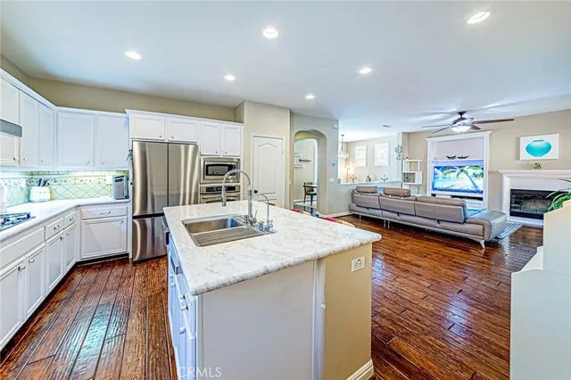 a kitchen with stainless steel appliances granite countertop a sink refrigerator and cabinets