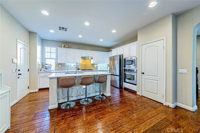 a open kitchen with white cabinets and stainless steel appliances