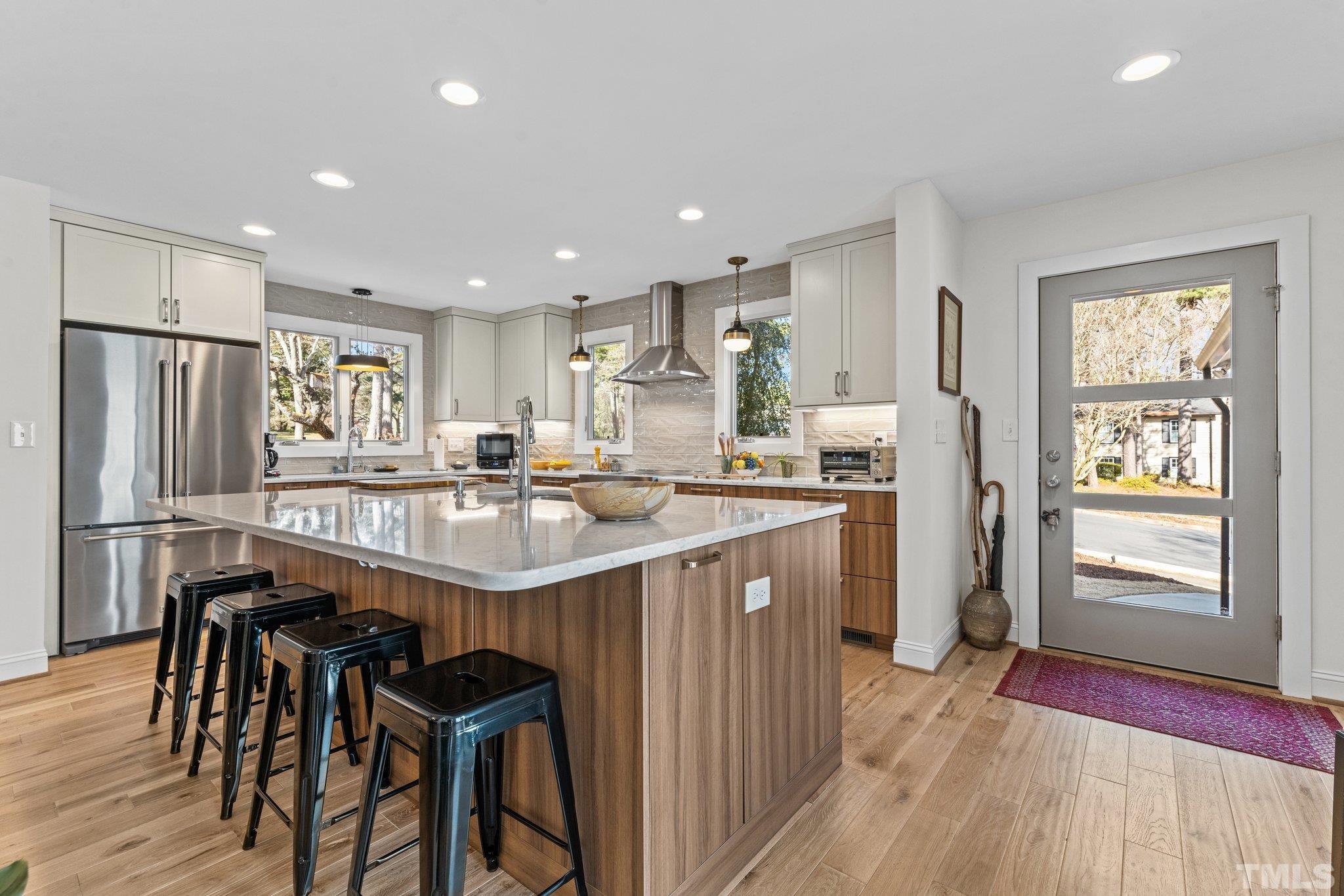 3036 Sylvania Drive Raleigh, NC 27607 - Photo 33 of 59 a kitchen with stainless steel appliances granite countertop table chairs refrigerator and wooden floor