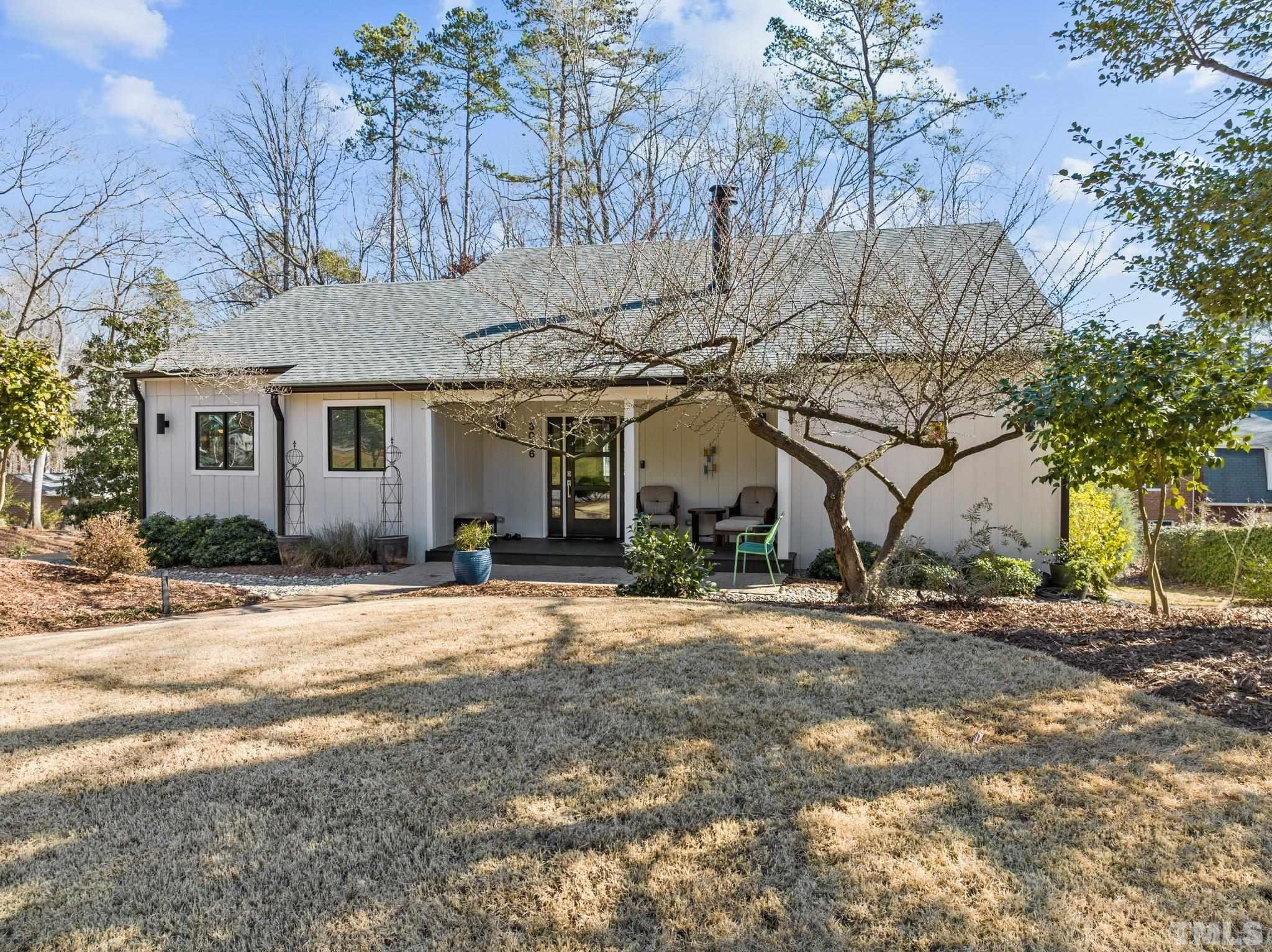 3036 Sylvania Drive Raleigh, NC 27607 - Photo 7 of 59 a front view of a house with a dirt yard and a large tree