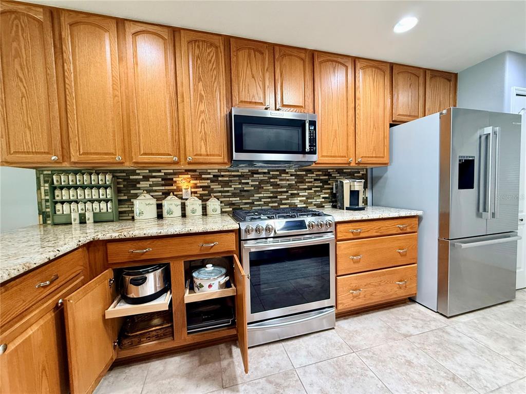 16296 Southwest 15th Court Ocala, FL 34473 - Photo 22 of 70 a kitchen with stainless steel appliances granite countertop a refrigerator and a stove top oven