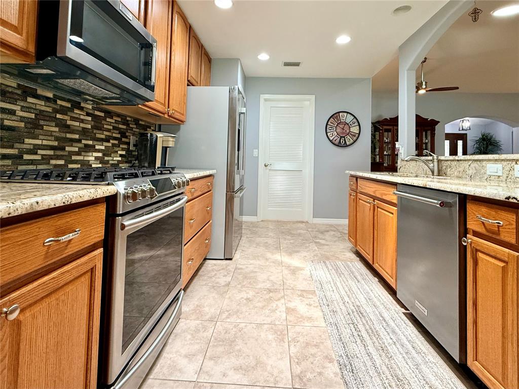 16296 Southwest 15th Court Ocala, FL 34473 - Photo 23 of 70 a kitchen with stainless steel appliances granite countertop a stove a sink and a refrigerator