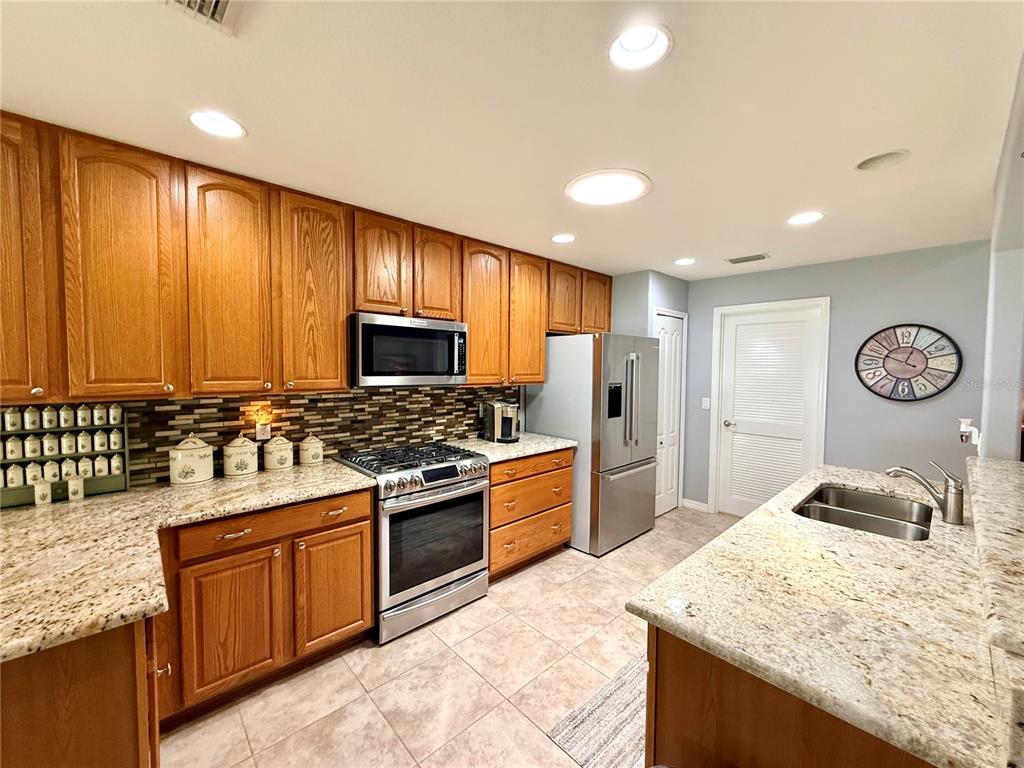 16296 Southwest 15th Court Ocala, FL 34473 - Photo 24 of 70 a kitchen with stainless steel appliances granite countertop a stove a sink and a refrigerator