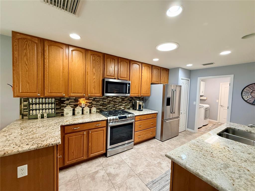 16296 Southwest 15th Court Ocala, FL 34473 - Photo 25 of 70 a kitchen with stainless steel appliances granite countertop a stove refrigerator sink and cabinets